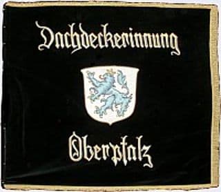 Eine Schwarze Fahne mit Wappen und Schriftzug der Dachdeckerinnung Oberpfalz
